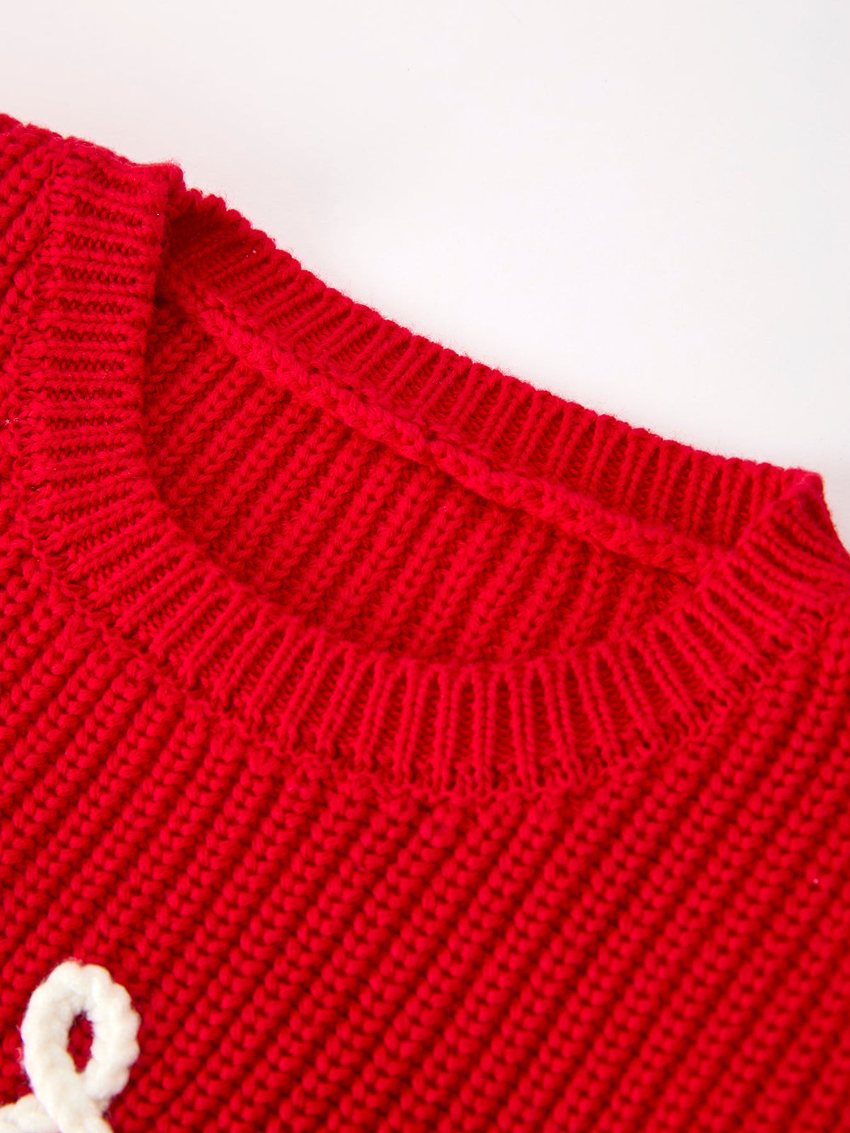 Red sweater neckline close-up with ribbed crew collar