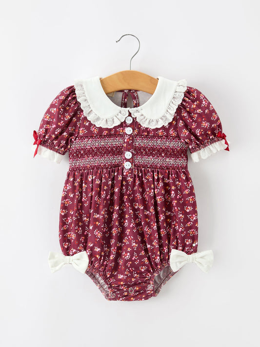 Burgundy floral baby bubble romper with Peter Pan collar, smocked bodice, white lace trim.