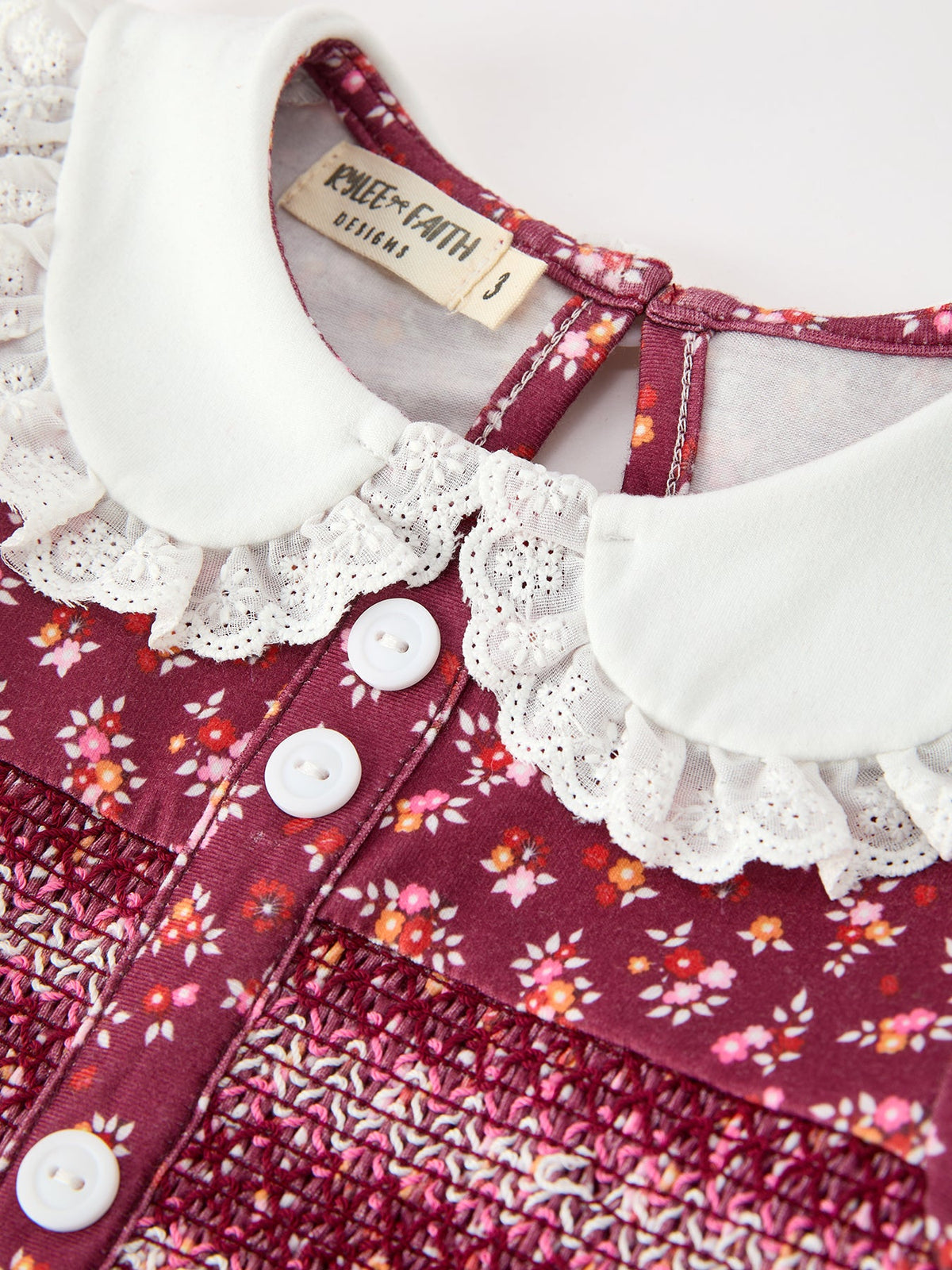 Girls dress close-up: white lace peter pan collar and button placket on burgundy floral