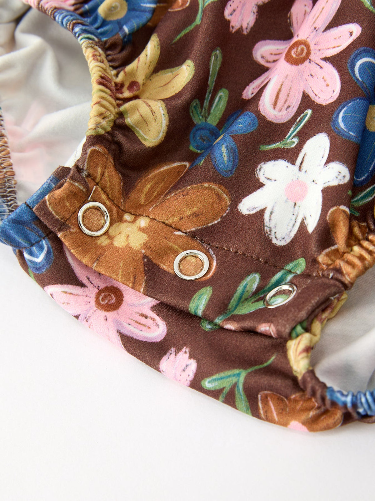 Brown floral snap-bottom romper with white side poppers and elastic leg openings