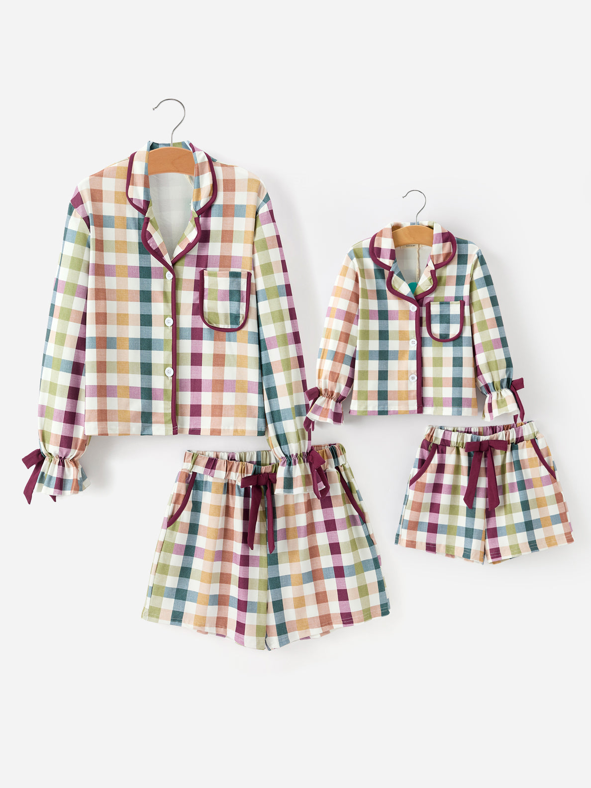 Two-piece plaid pajama set for adults and children on hangers, long top and shorts