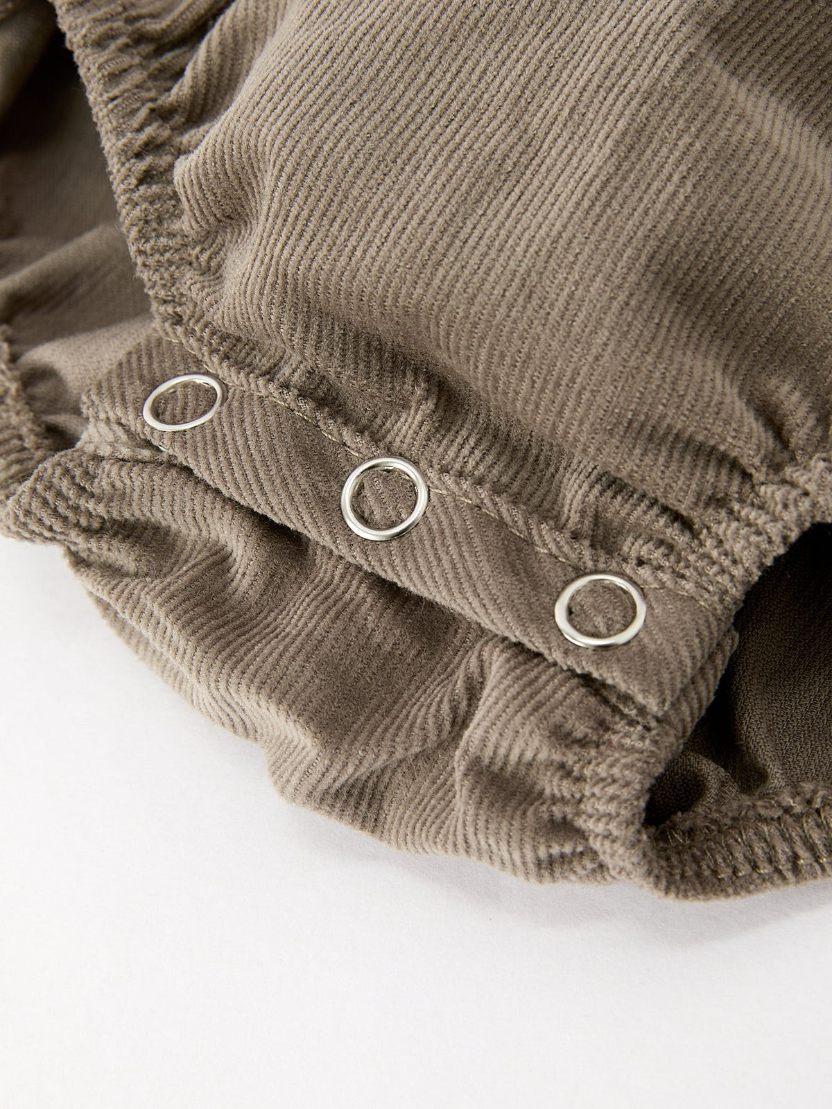 Taupe romper with gathered leg openings and snap button closure