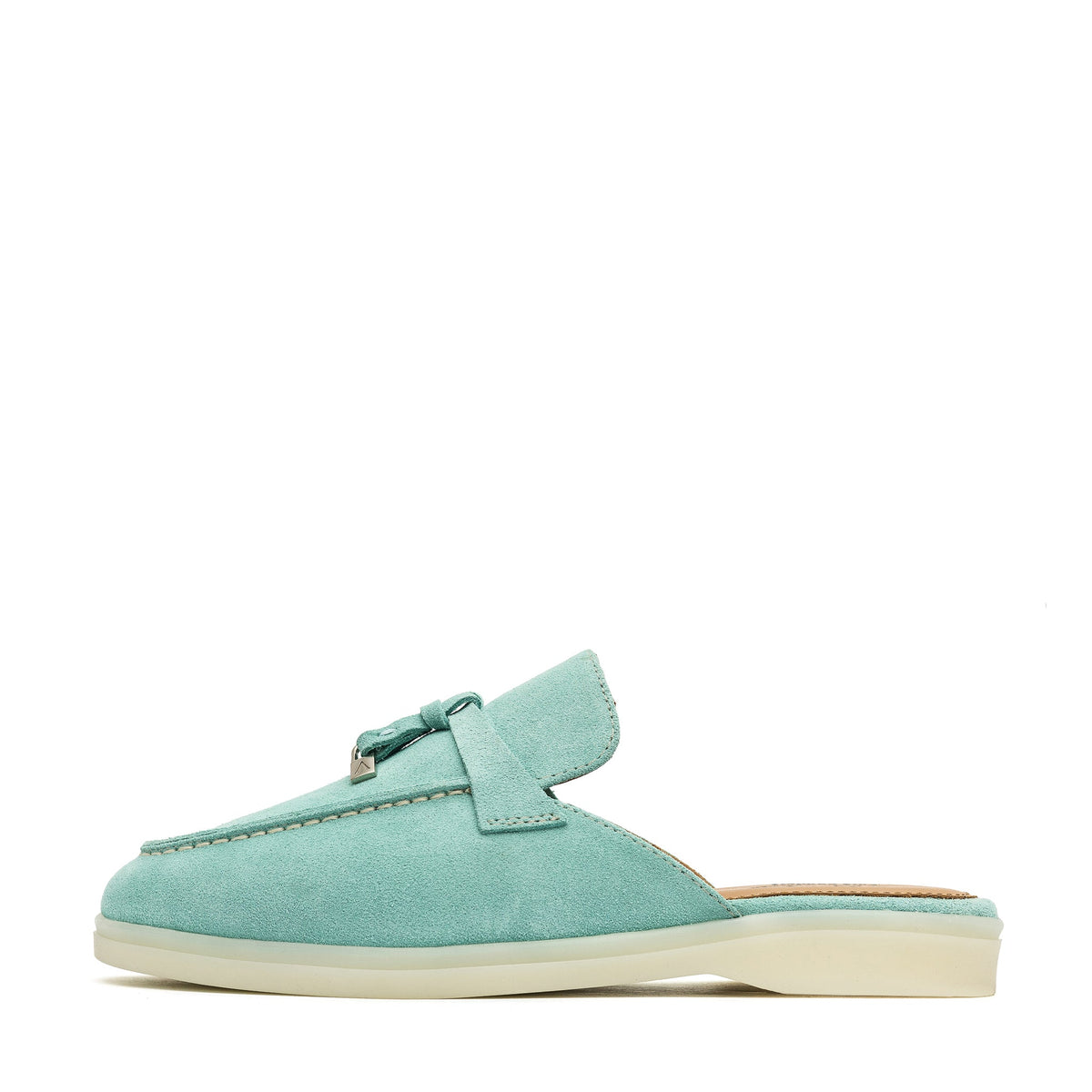 Turquoise suede mule in side profile with a flat cream sole and metal tassel detail