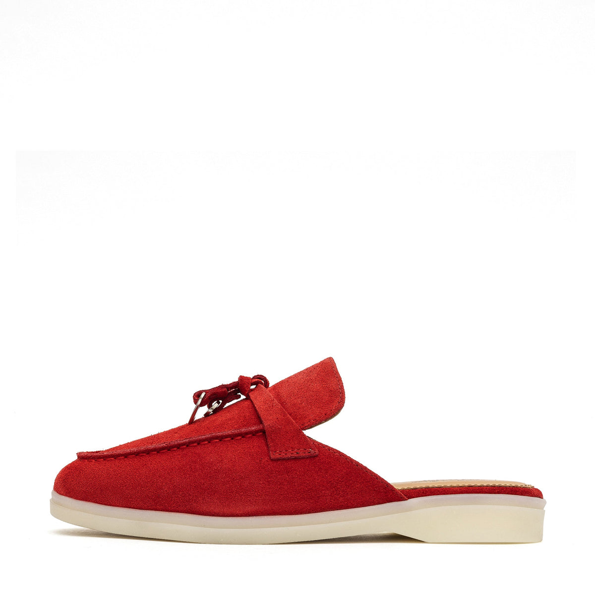 Side view of a red suede mule with a cream sole and tassel detail.
