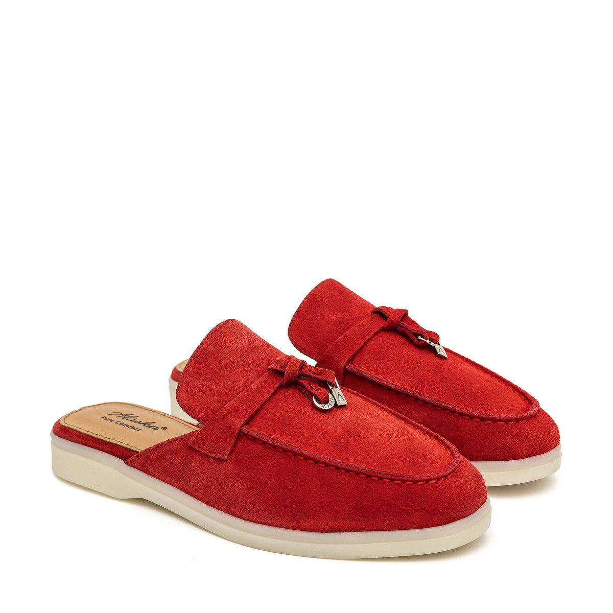 Pair of red suede mules with moc toes, tassel accents, and cream soles.