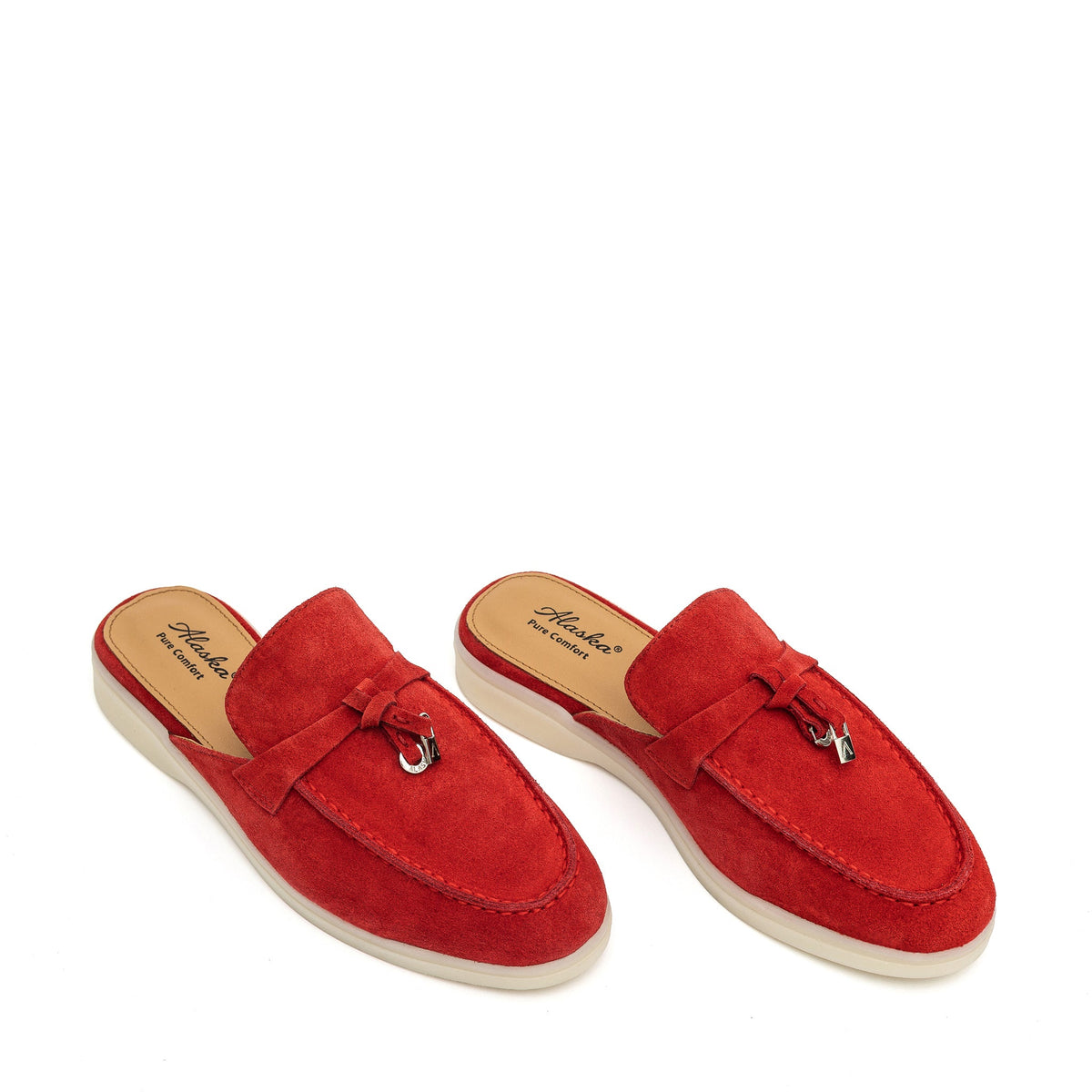 Pair of red suede mules with moc toes, metal-accented tassels, and cream soles.