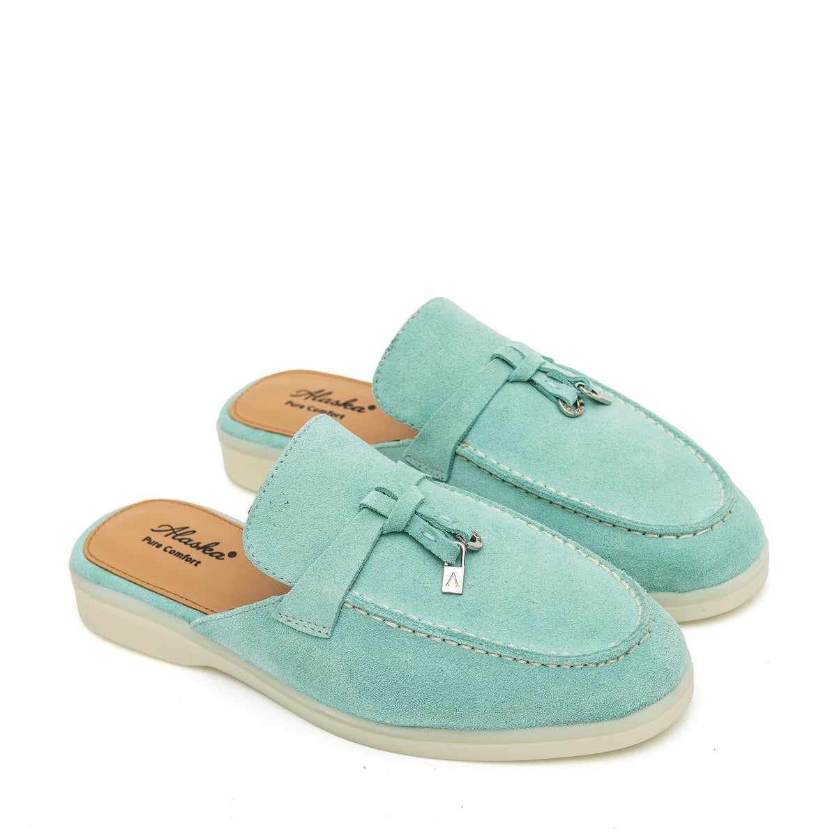 Pair of turquoise suede mules with moc stitching, metal tassels, and cream soles