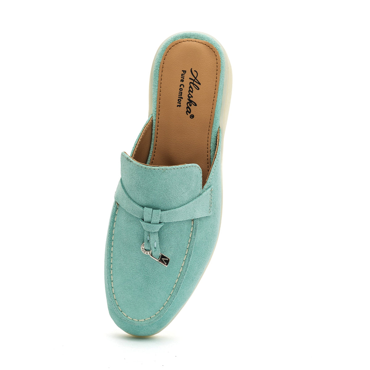 Turquoise suede mule viewed from above, with moc stitching and a metal tassel
