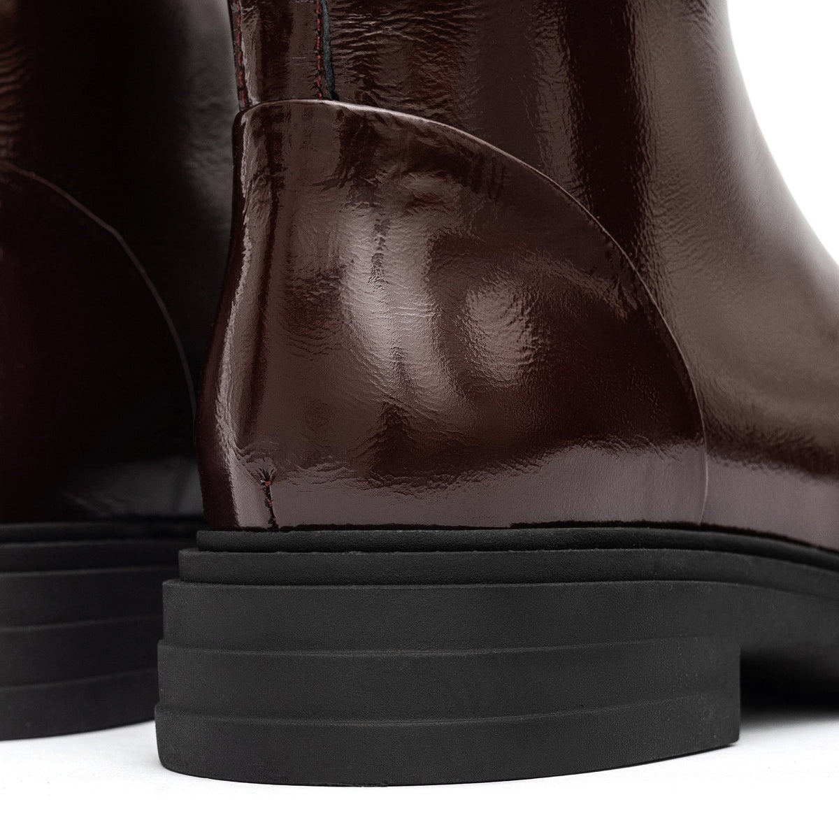 Close-up of the burgundy leather boot heel and layered black sole