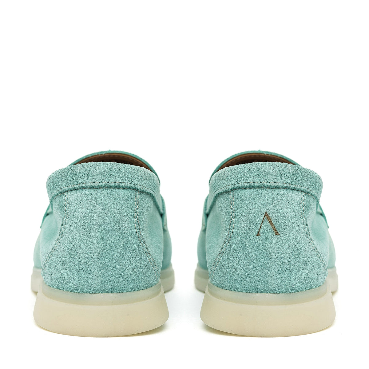 Turquoise suede loafers showing stitched heel panels and cream soles
