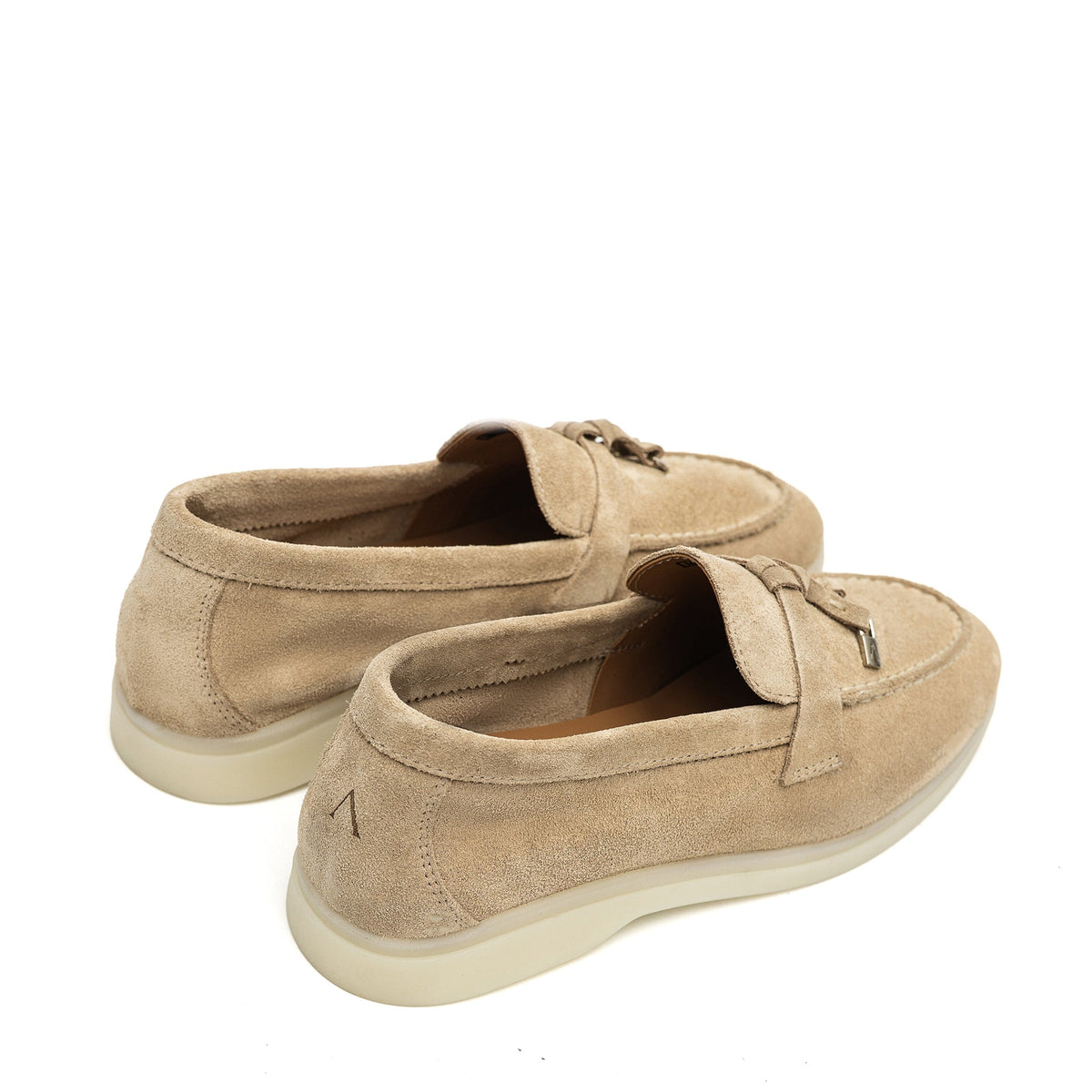 Pair of beige suede loafers viewed from the rear side, showing heel seams and cream soles
