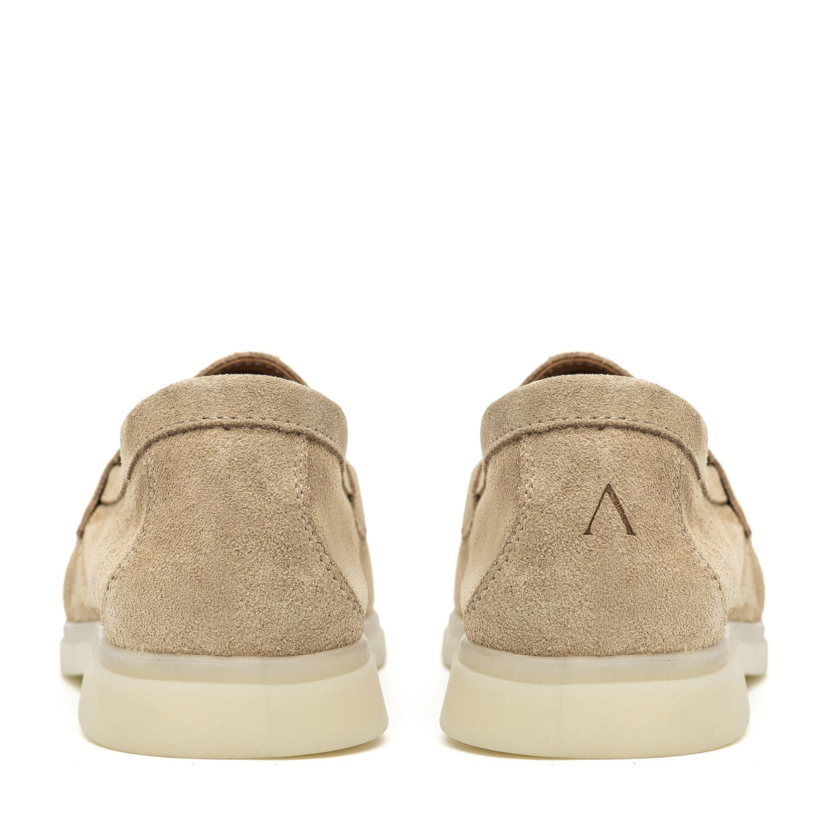 Pair of beige suede loafers viewed from behind, with logo marks on the heels