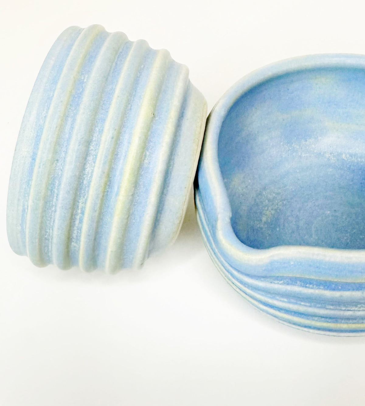 Pair of blue ceramic matcha bowls with ribbed sidewalls and scalloped rim