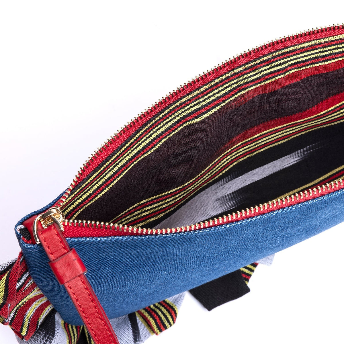 Blue denim clutch close-up: red zipper track with leather pull and striped edge