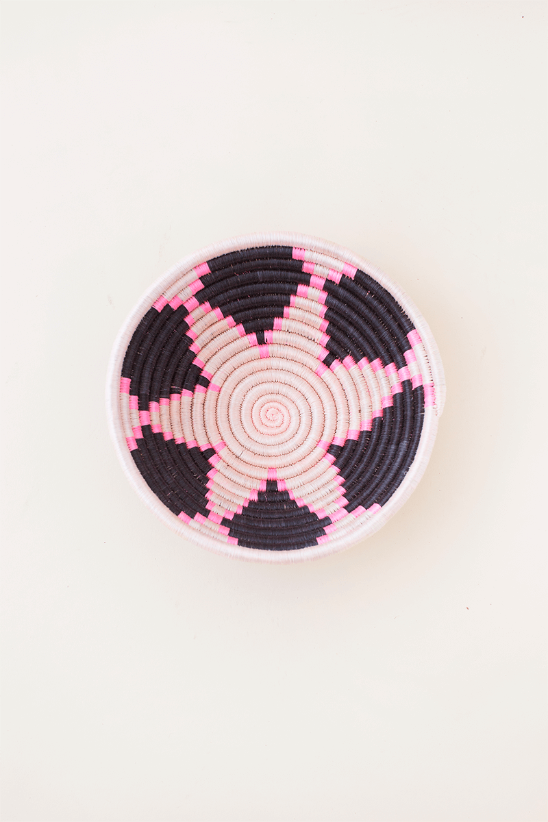Round woven coaster with pink diamond spiral on dark base, mini size