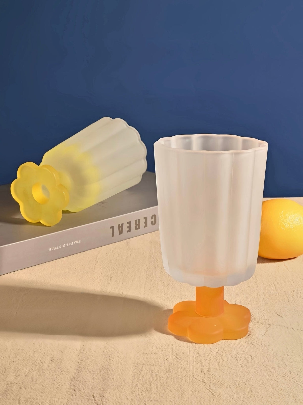 Hand-blown petal goblet glasses, pale yellow and white, with orange stemmed bases.