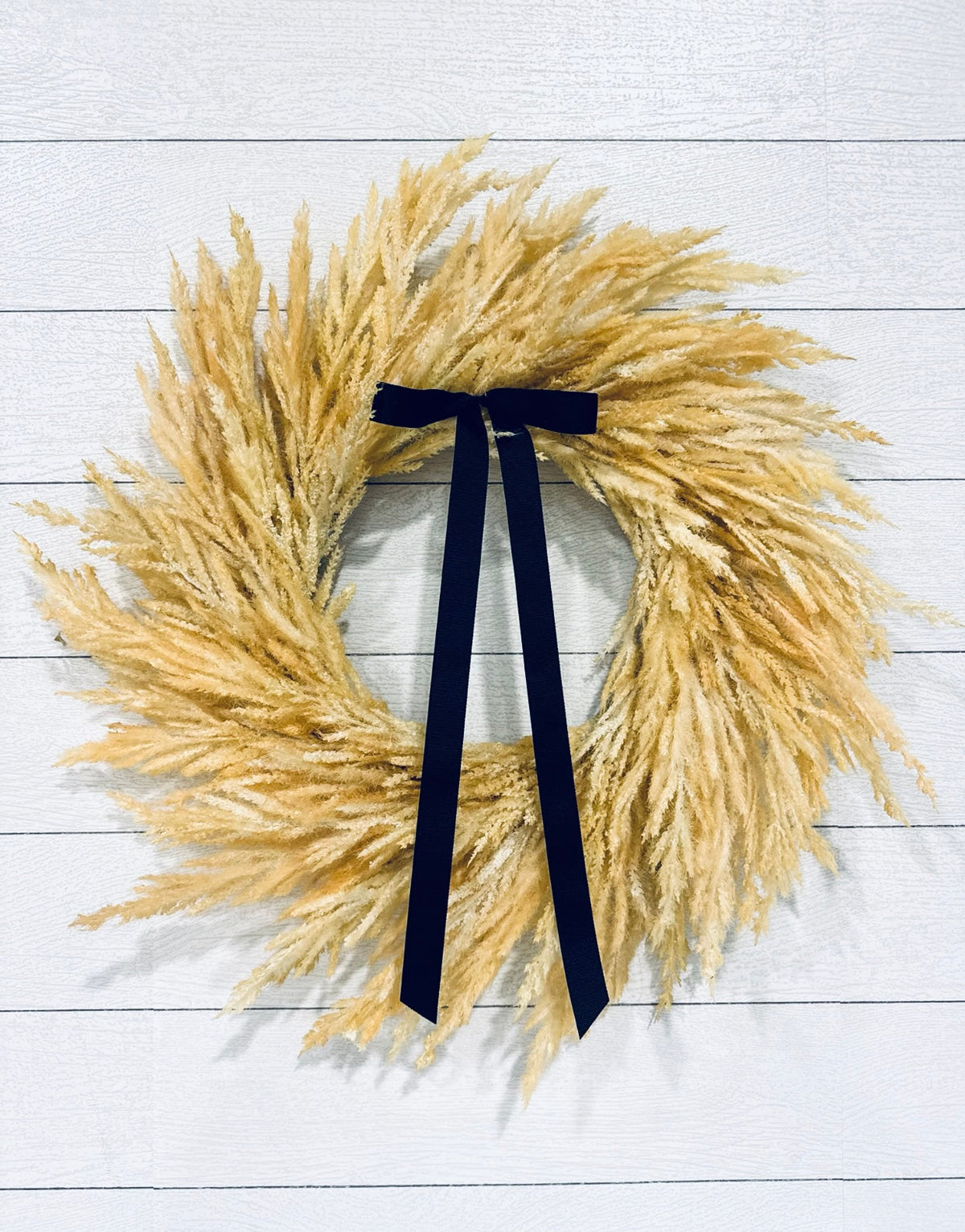 Pampas wreath with navy bow ribbon and golden feathery fronds