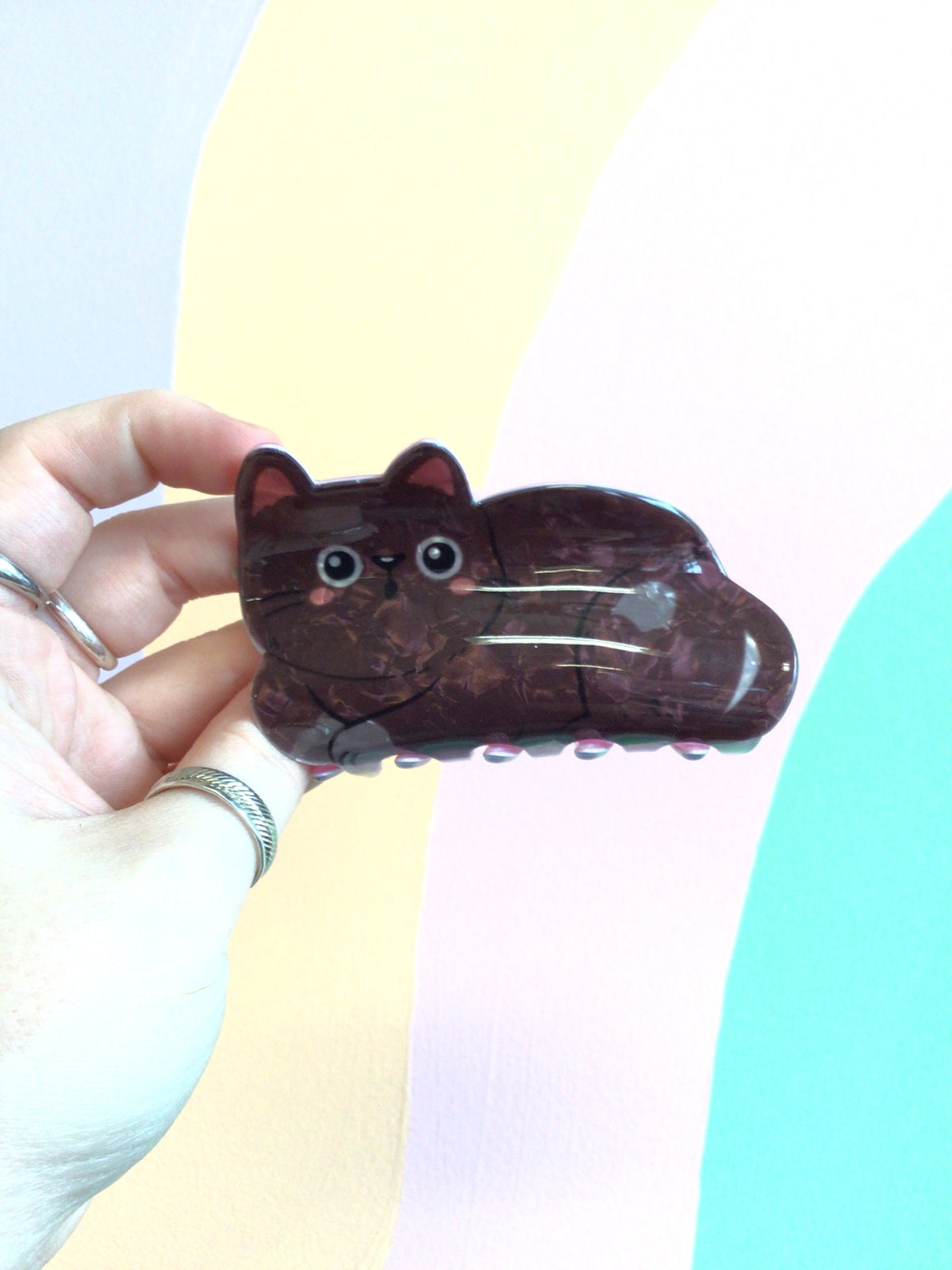 Dark brown cat hair claw with blue eyes and curved tail design