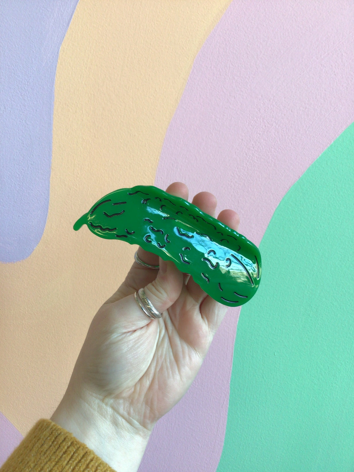 Pickle-shaped hair claw in dark green with lighter green texture spots