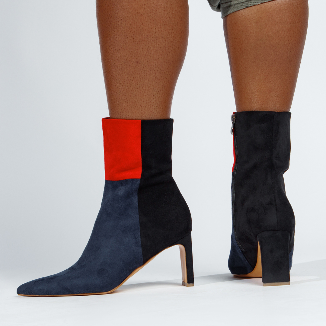 Pair of color-block ankle booties with red and black ankle band, navy suede, high heel