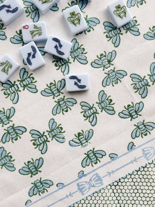 Table throw fabric with repeating blue and green floral pattern and light blue trim border.