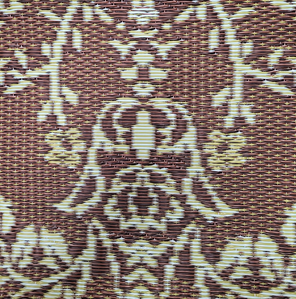 Outdoor mat detail with brown and teal floral medallion pattern