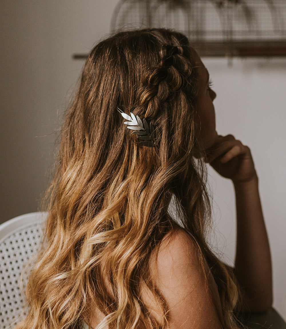 Silver fern hair clip barrette on back view of wavy brown hair