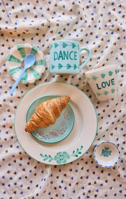 Flower-shaped ceramic dipping bowl with teal-green painted stripes and floral rim detail
