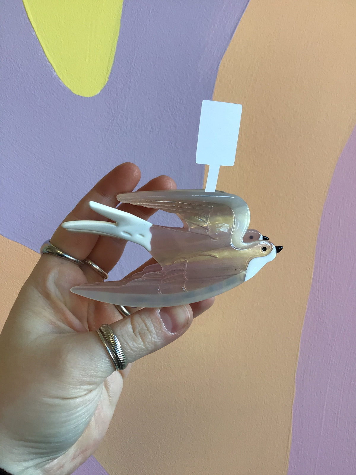 White swallow hair claw with translucent wings and two-prong snap clip