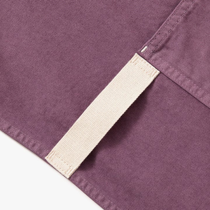 Lavender purple apron fabric close-up with cream strap edge and stitching