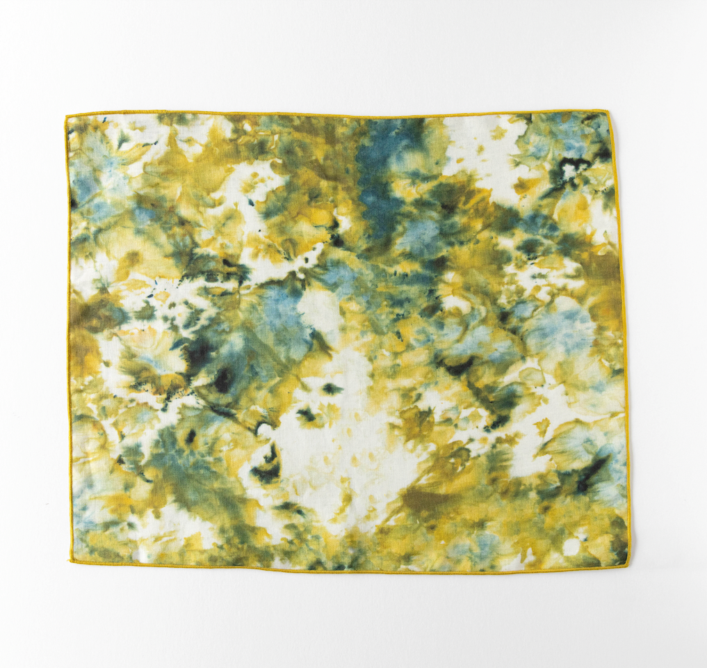 Square marble-look placemat in green and yellow with thin gold border trim