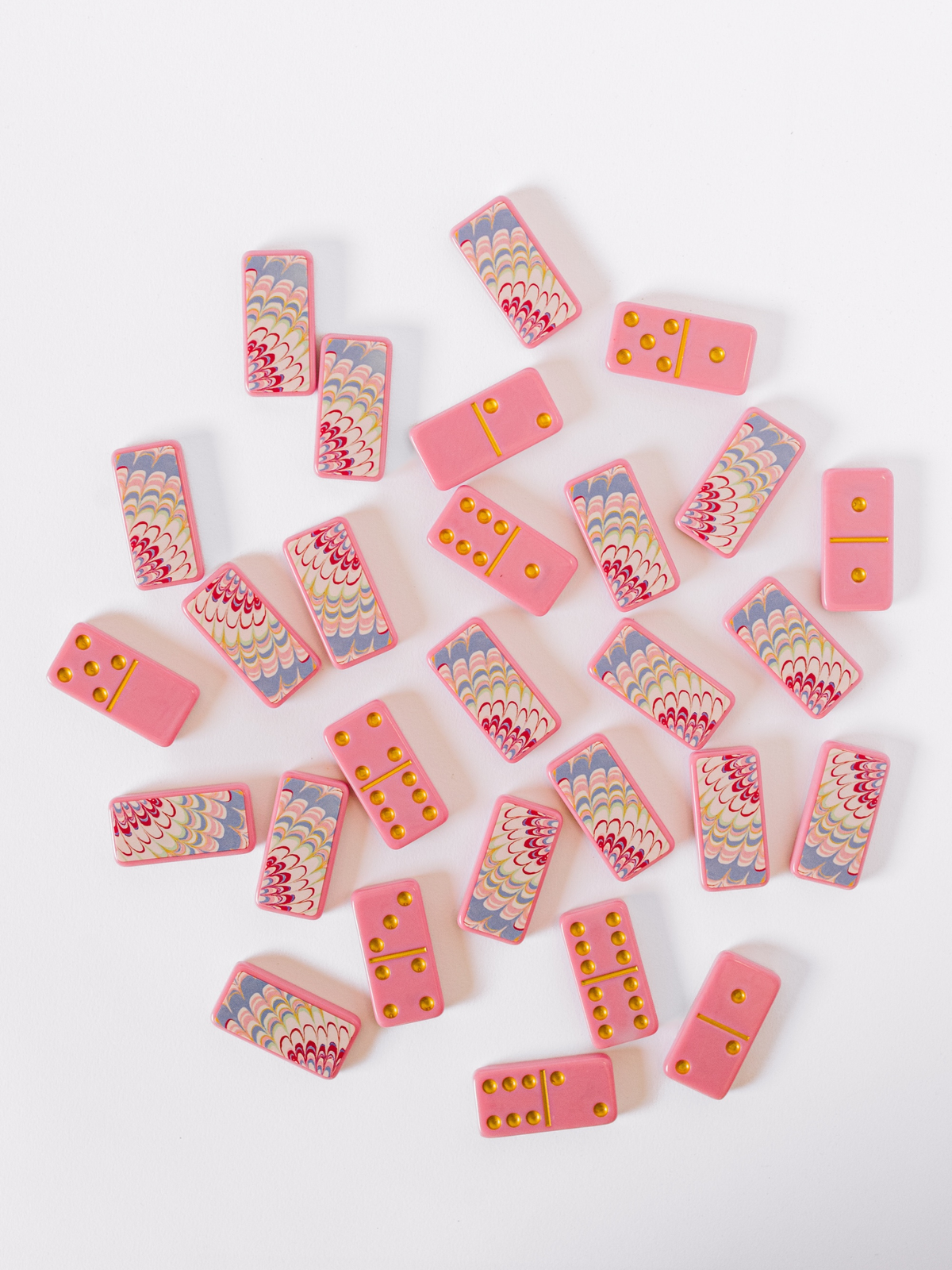More scattered pink domino tiles with yellow dot pips and pink backs