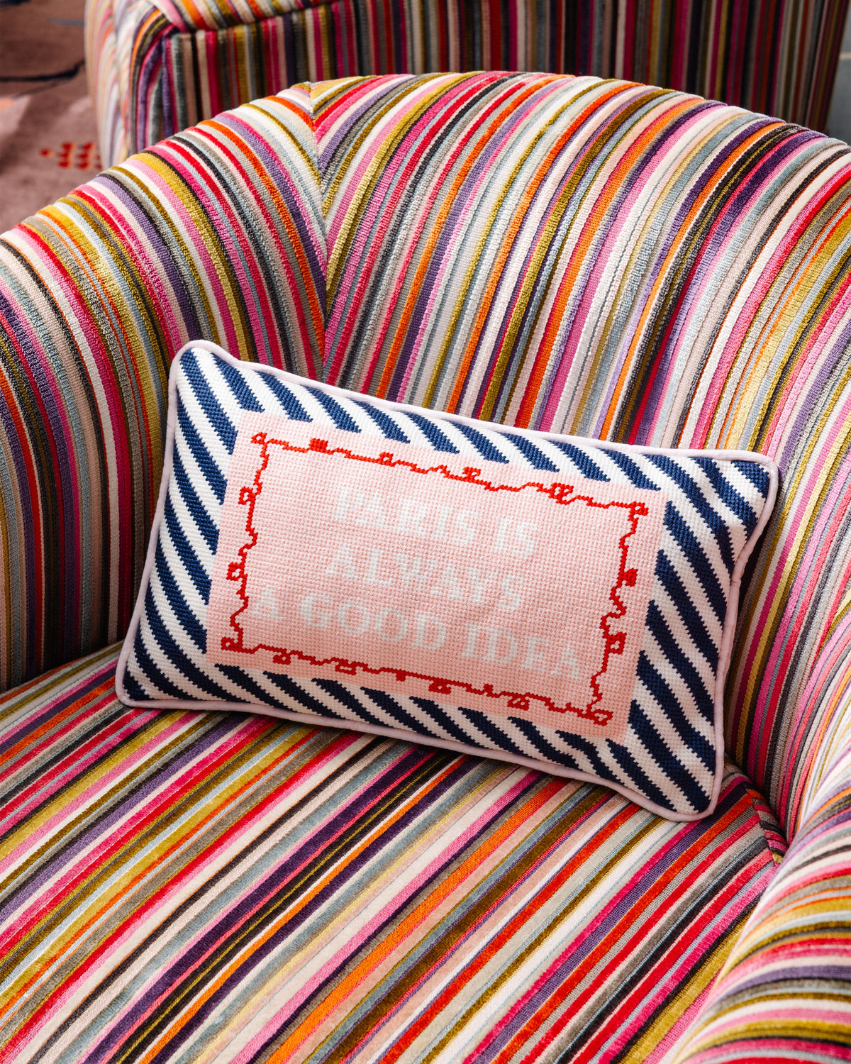 Needlepoint lumbar pillow with navy chevron border and pink Paris quote embroidery