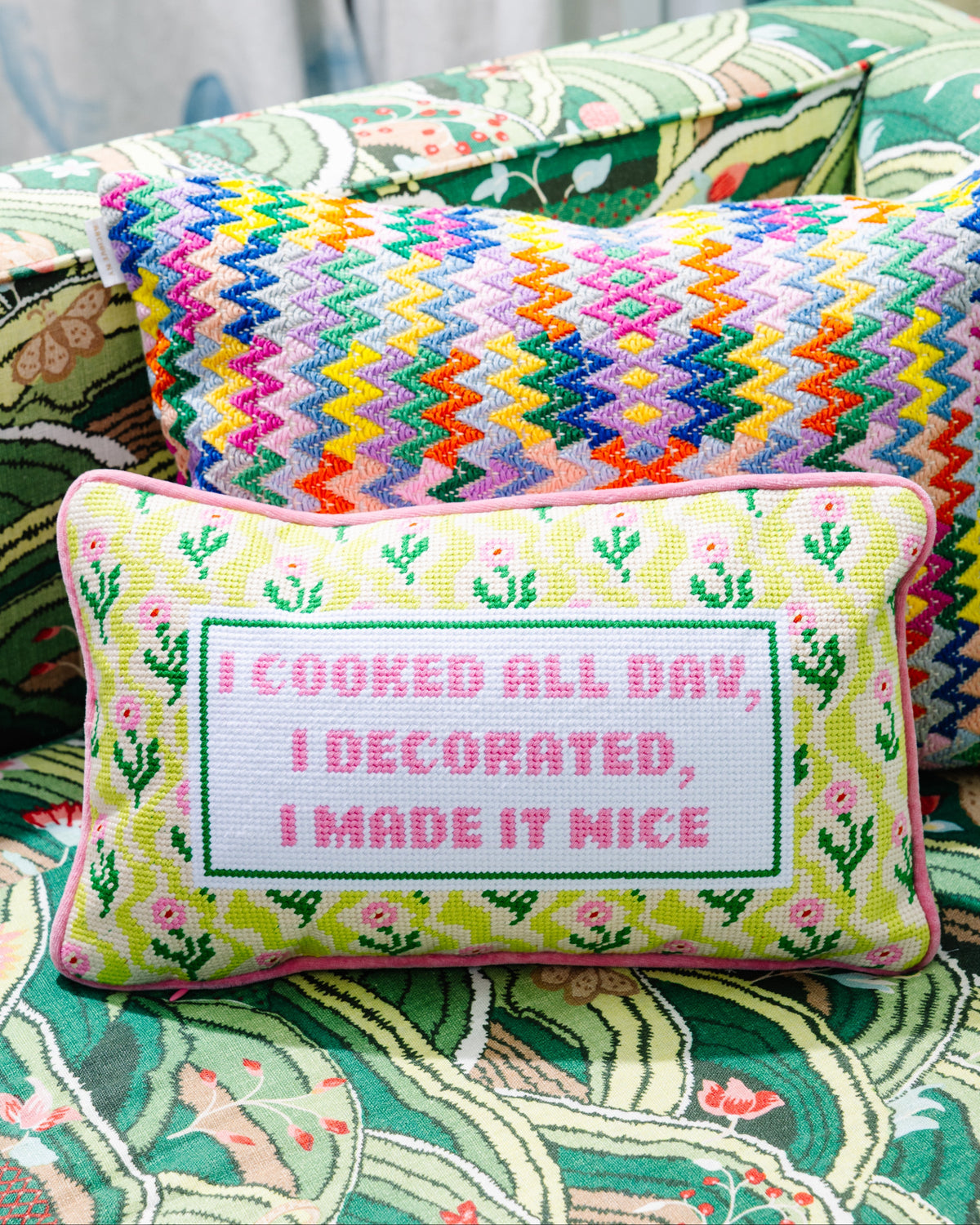 Needlepoint decorative pillow with pink trim, green vine pattern, “I made it nice”