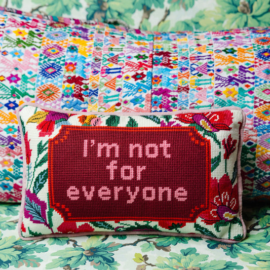 Red needlepoint throw pillow with floral border, "I'm not for everyone" needle-stitched text