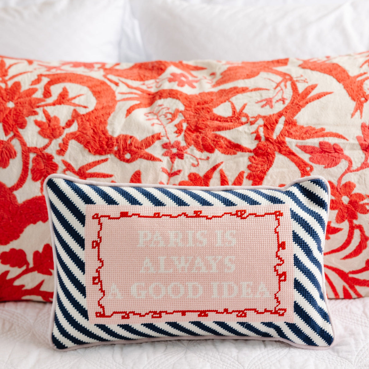 Needlepoint pillow with navy zigzag border and pink embroidered Paris quote