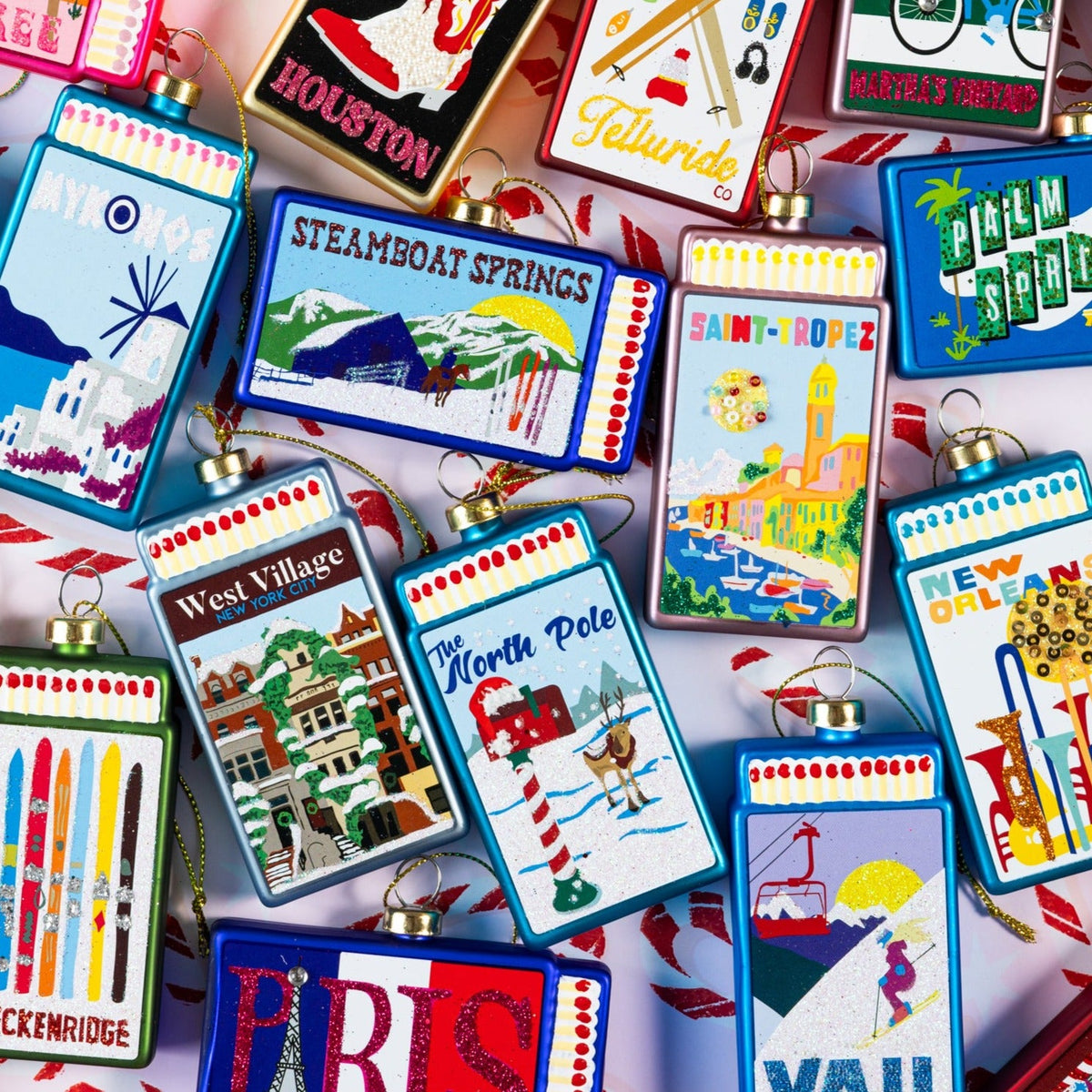 Assorted matchbook ornaments featuring a blue “The North Pole” ornament among others.