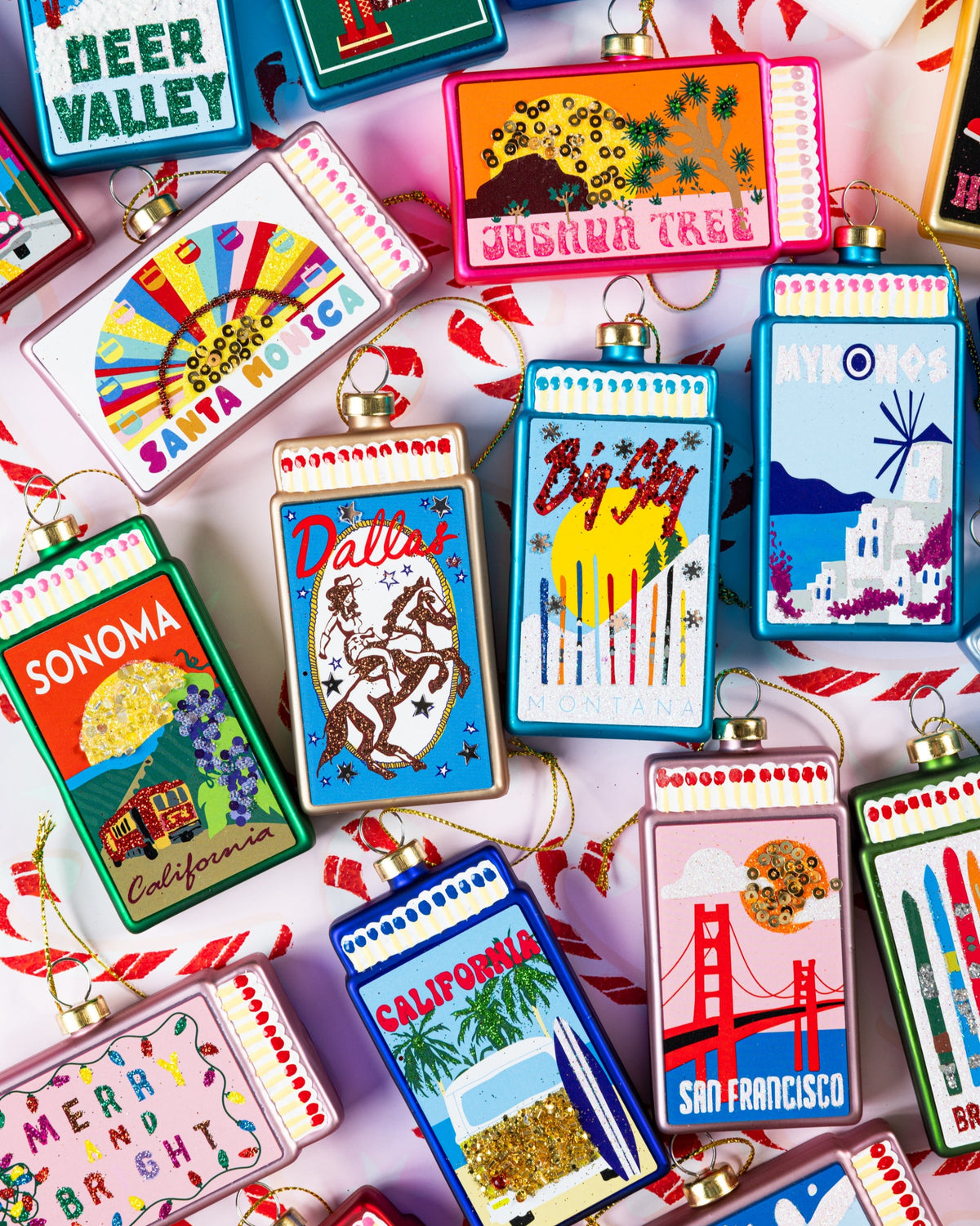 Colorful matchbook ornament assortment with gold hangers and printed artwork