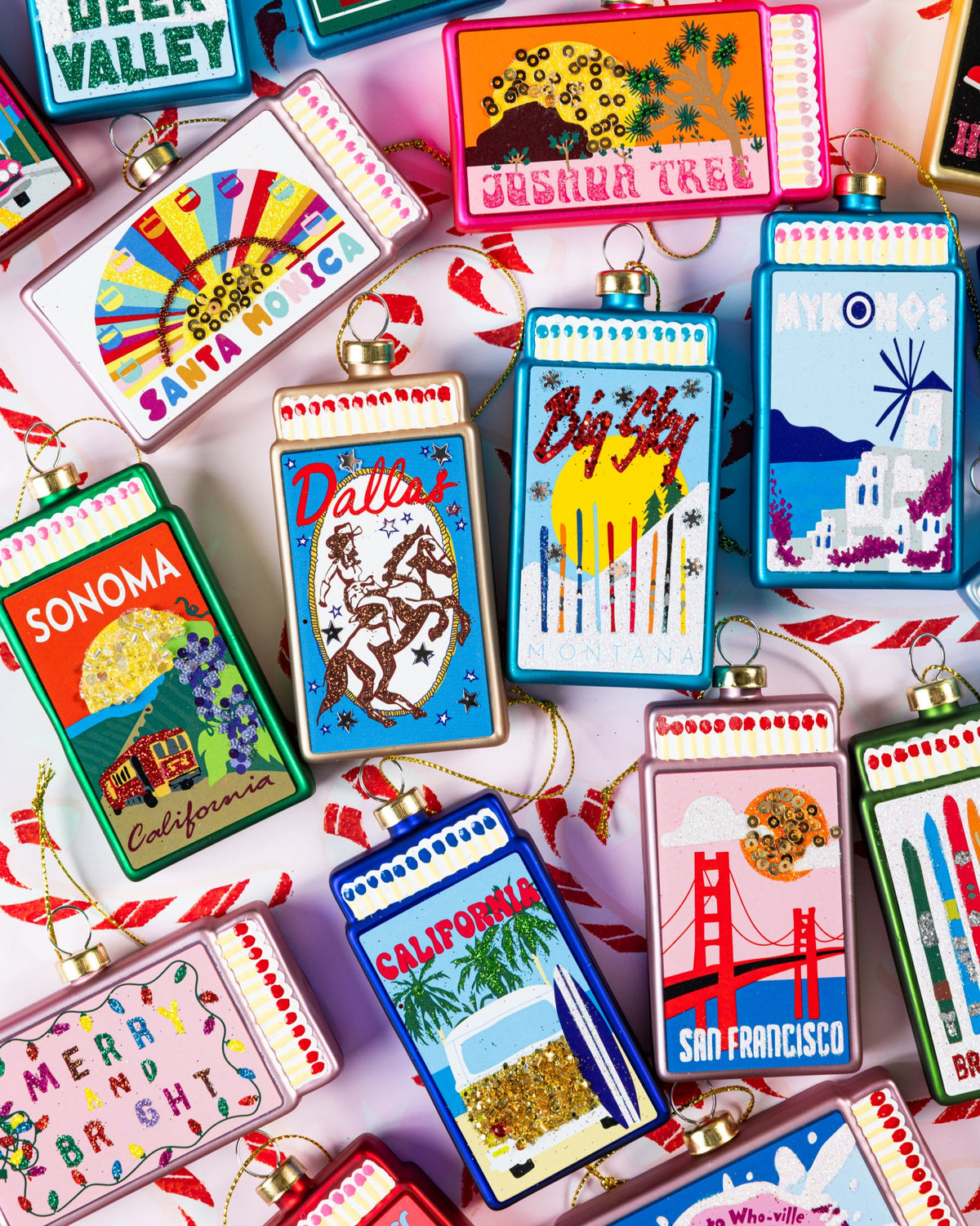 Assorted matchbook-style ornaments with colorful front designs and gold caps
