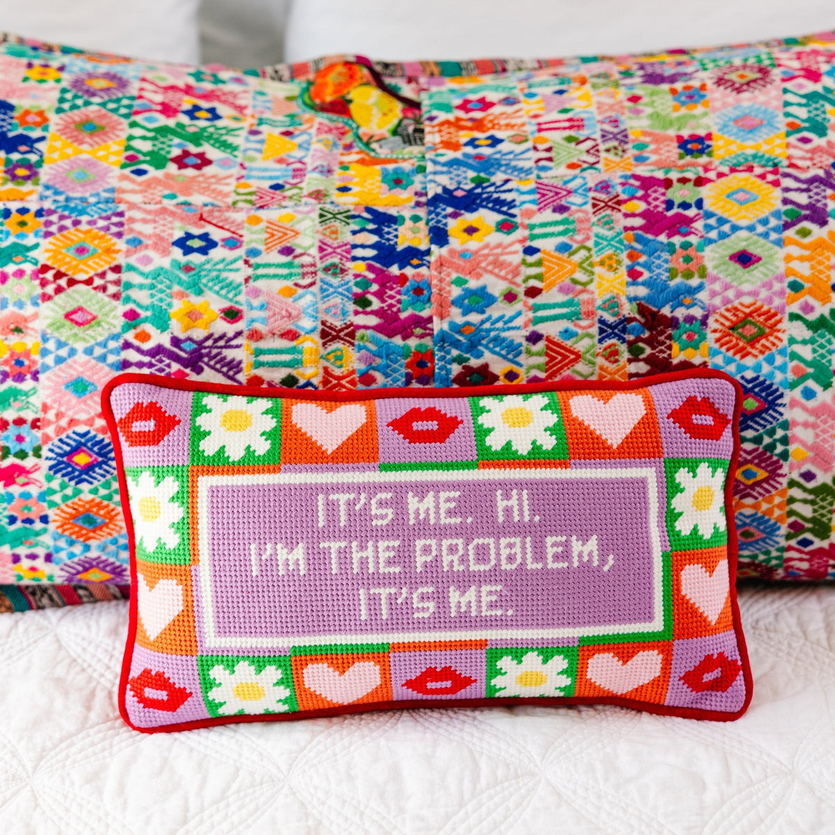 Needlepoint decorative pillow with red trim, heart pattern, and purple "It's me" quote panel