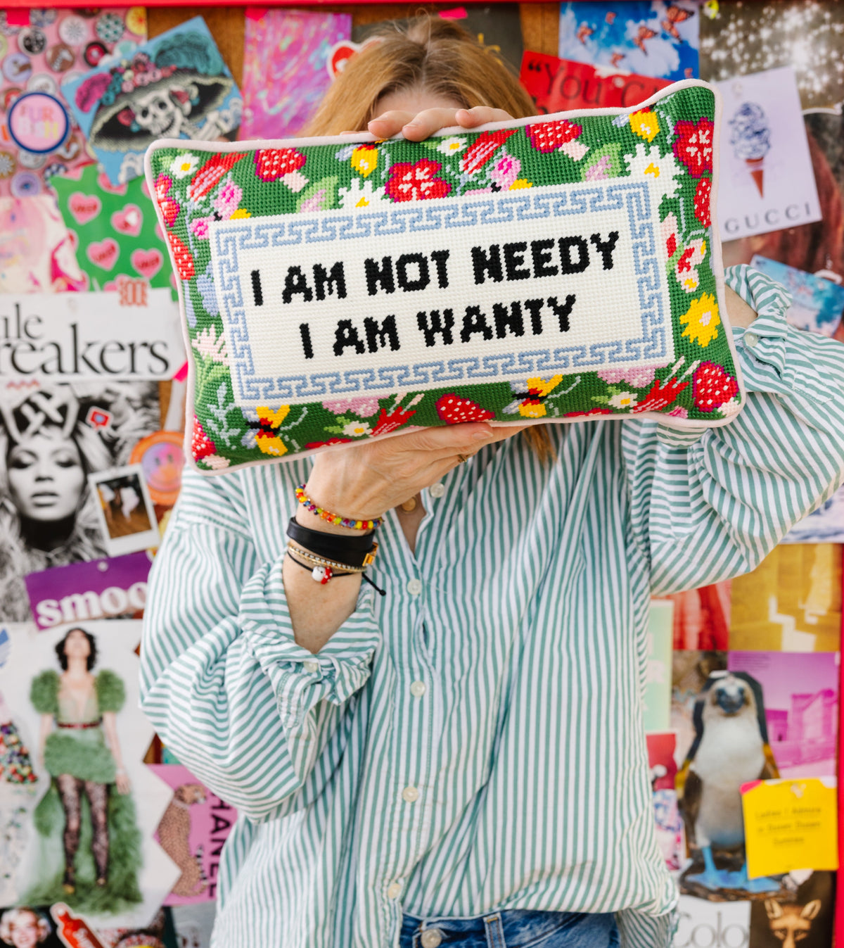 Green needlepoint pillow with "I AM NOT NEEDY" and "I AM WANTY" stitched on front