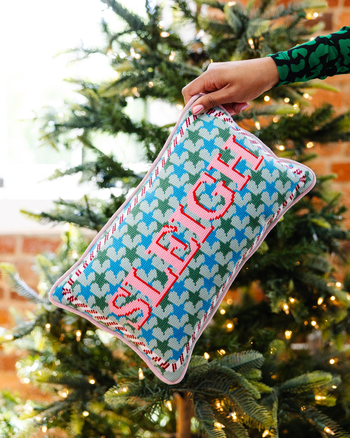 Teal needlepoint holiday pillow with green and blue pattern and red 'SLEIGH' lettering