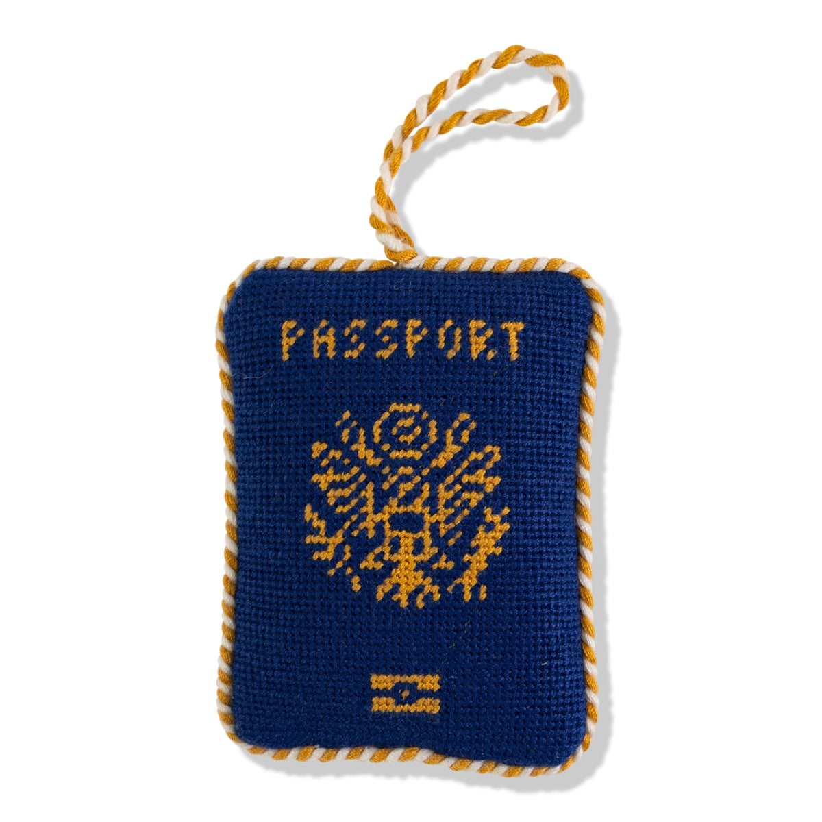 Blue needlepoint passport icon ornament with gold lettering and rope loop hanger.