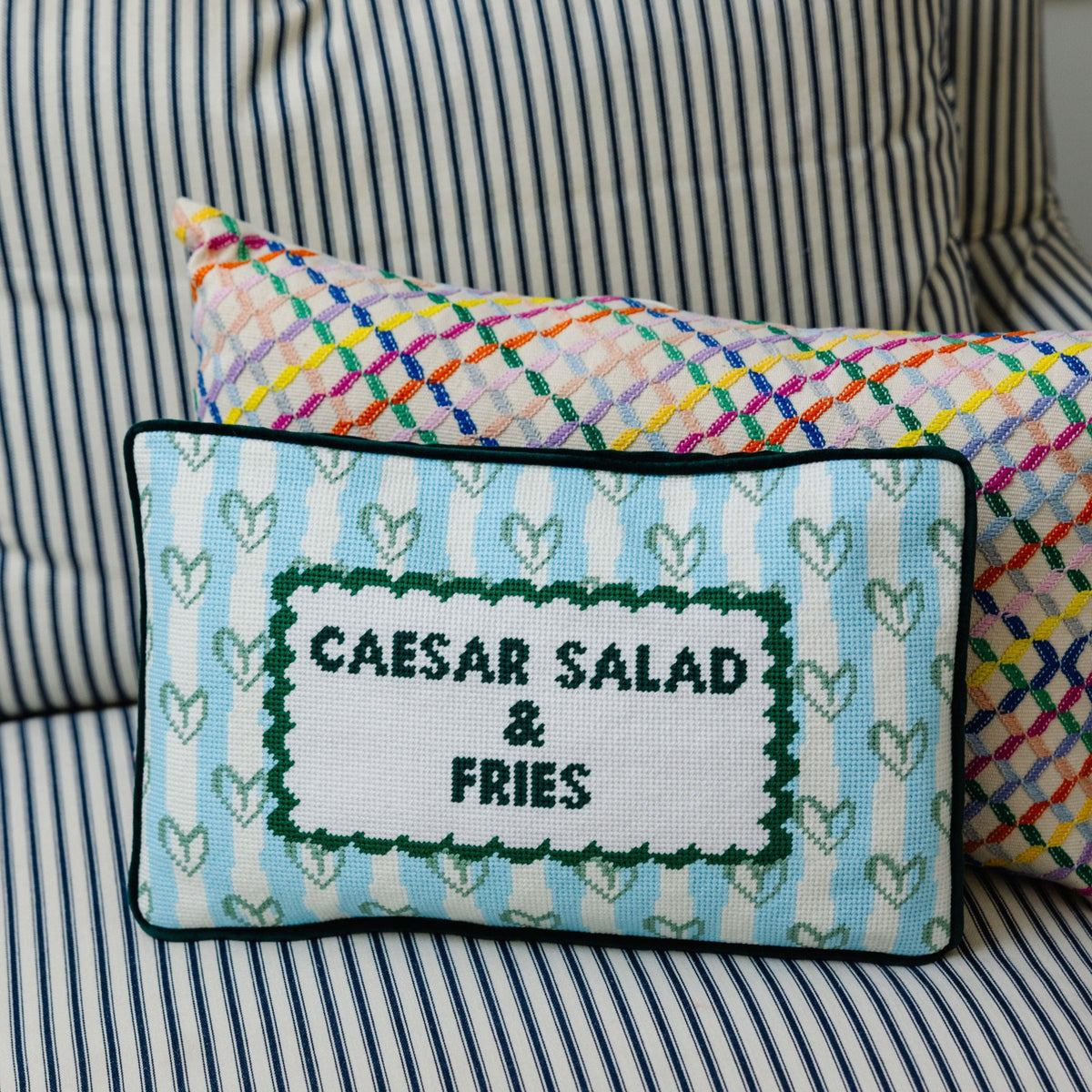 Needlepoint lumbar pillow with Caesar salad & fries stitch design on blue heart pattern