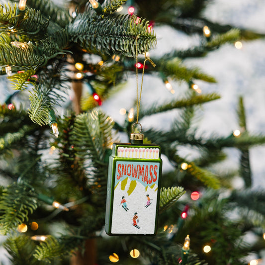 Snowmass matchbook ornament hanging on a gold cord from a Christmas tree