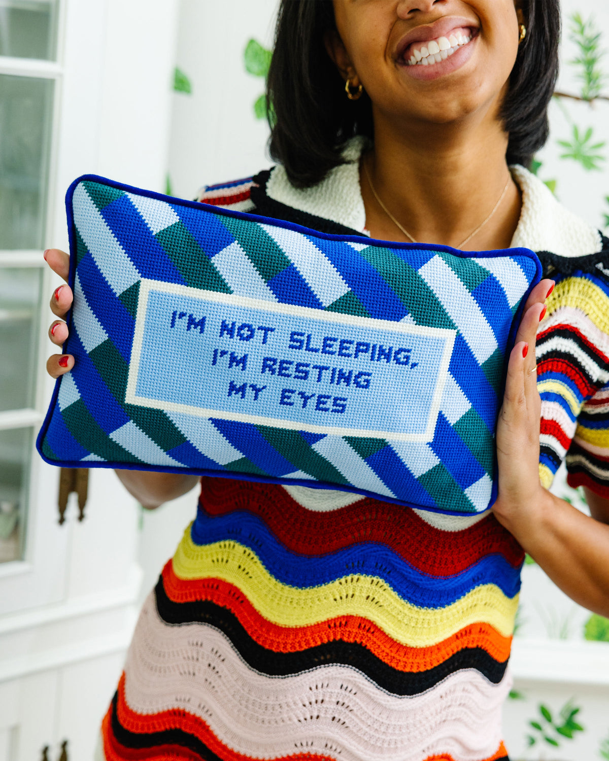 Needlepoint pillow with blue geometric chevrons and “I'm resting my eyes” message