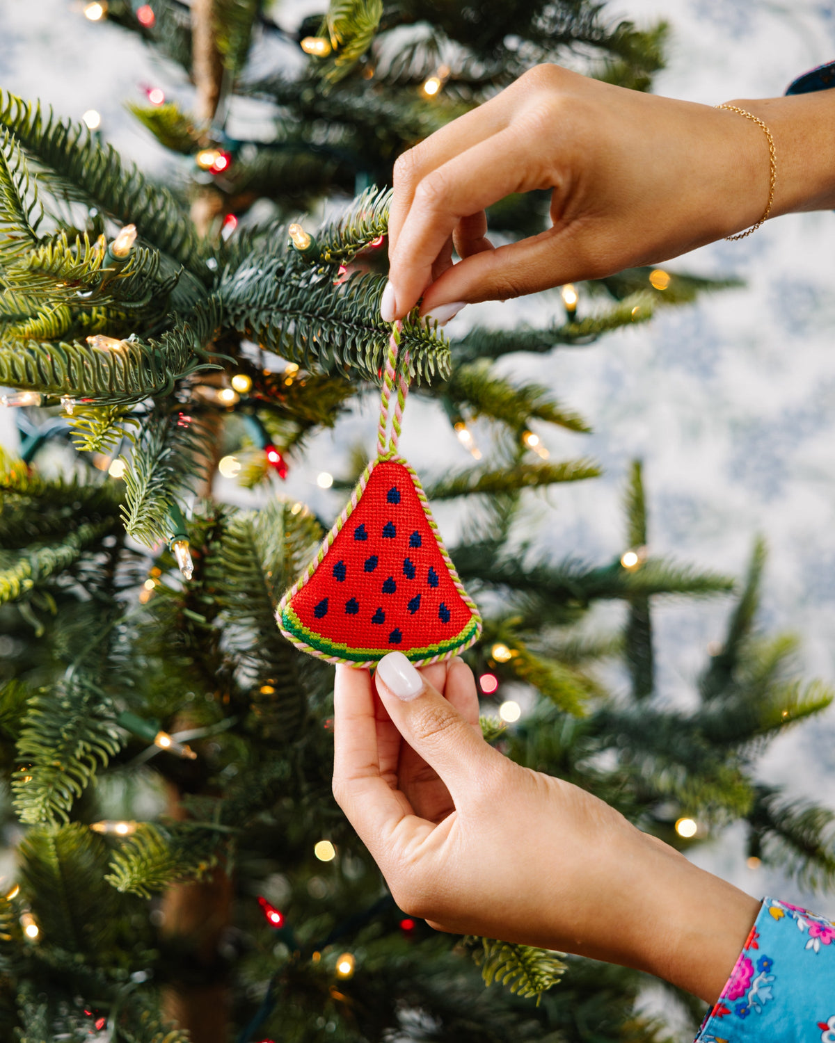 Watermelon needlepoint ornament placed on tree, red triangular slice with blue seeds and green edge