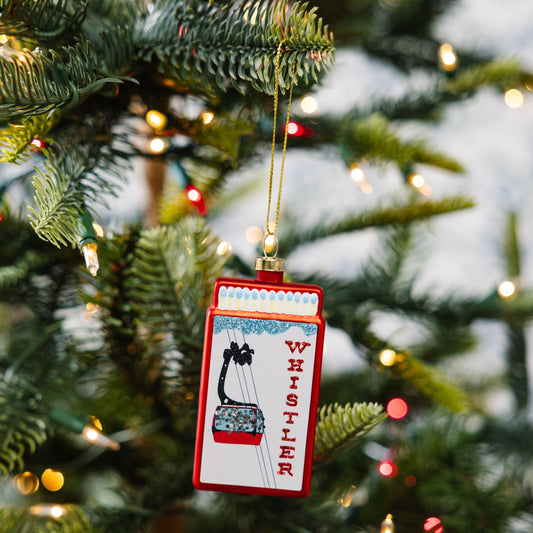 Whistler matchbook ornament hanging on Christmas tree, red frame and white panel