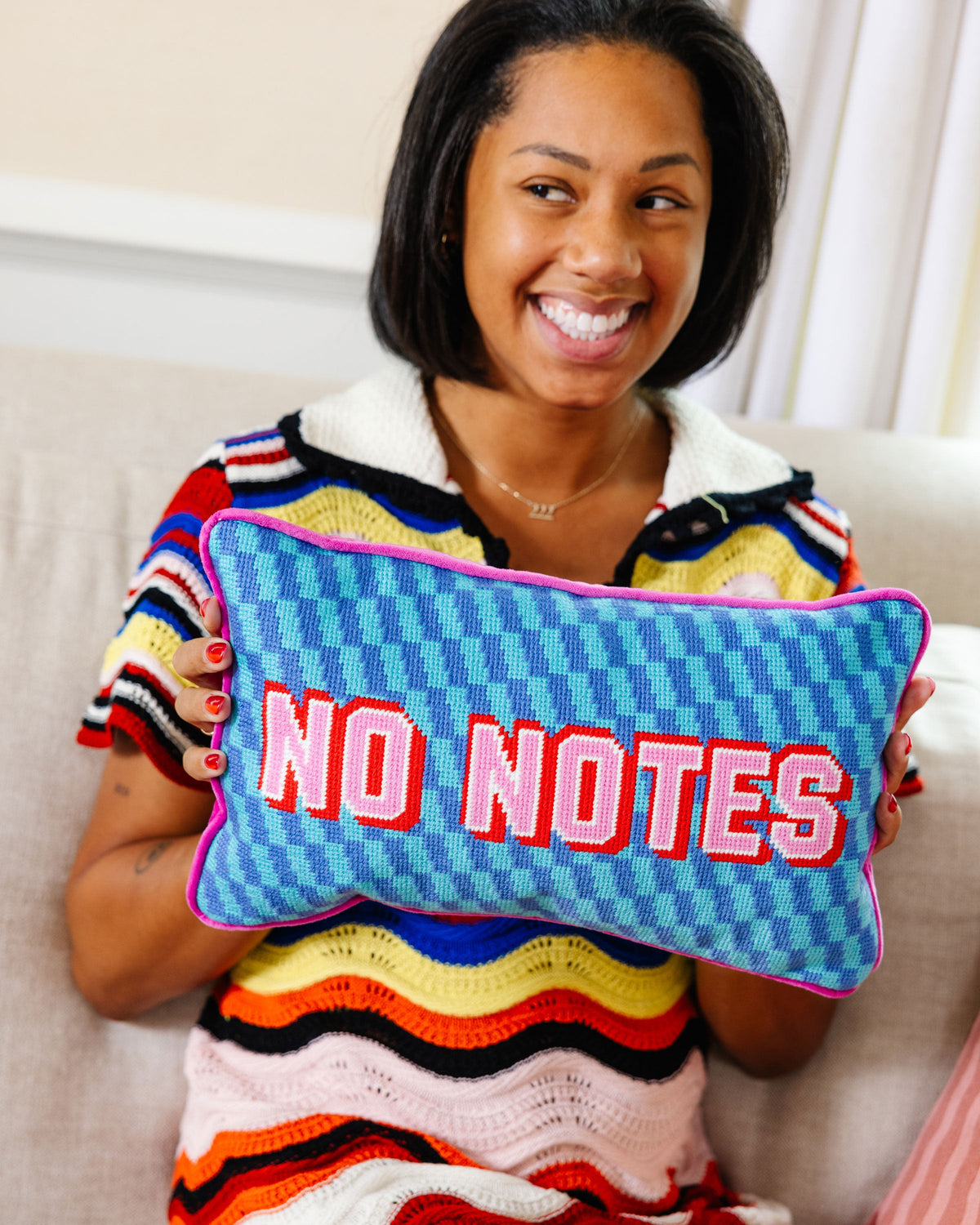 Blue needlepoint pillow with “NO NOTES” embroidery and purple edge piping