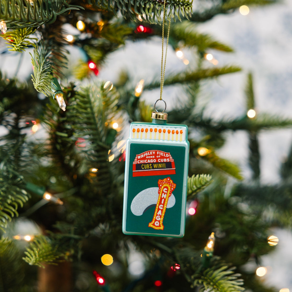 Teal matchbook ornament hanging on a Christmas tree, Chicago Cubs design